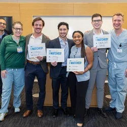 Dan Luca and his classmates on Urology Match Day. Dr. Brisbane (far right) congratulates Dr. Luca, who is standing to the immediate left of him.